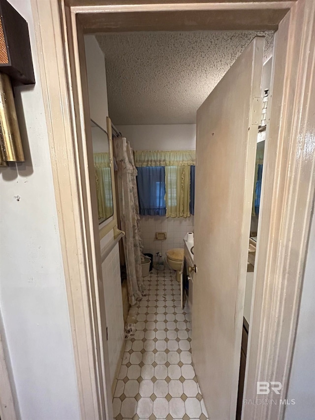 bathroom featuring vanity, toilet, and a textured ceiling