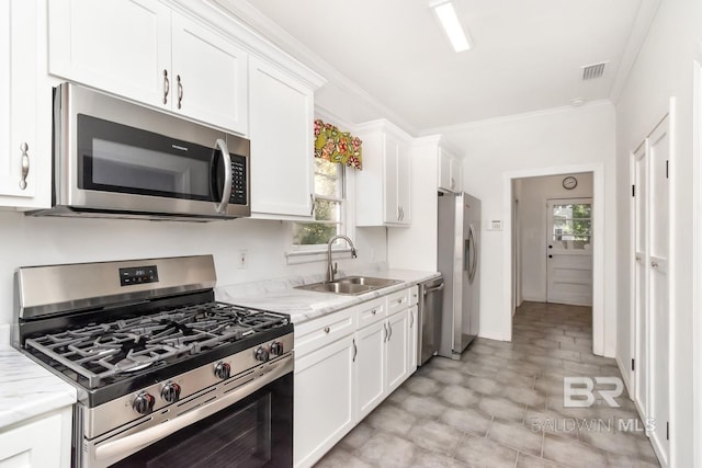 kitchen featuring stainless steel appliances, white cabinetry, plenty of natural light, and sink