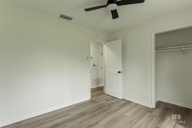 unfurnished bedroom featuring a closet, visible vents, ceiling fan, wood finished floors, and baseboards