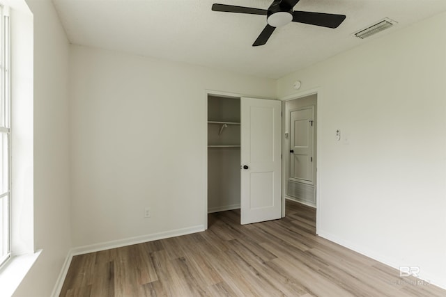 unfurnished bedroom with light wood-type flooring, a closet, visible vents, and baseboards