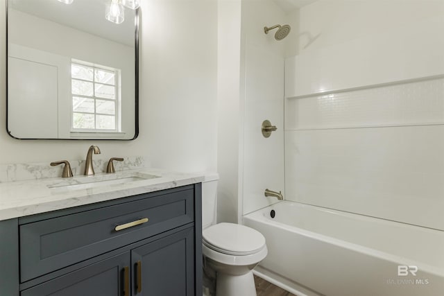 full bath featuring wood finished floors, shower / washtub combination, vanity, and toilet