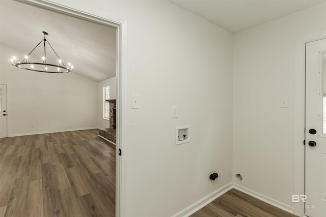 clothes washing area with a chandelier, hookup for a washing machine, laundry area, wood finished floors, and baseboards