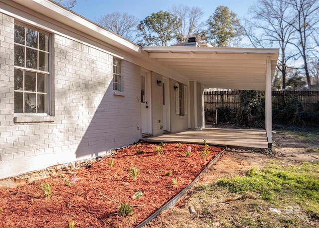 doorway to property with fence and brick siding