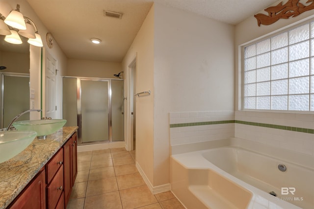 bathroom with vanity, a textured ceiling, tile patterned flooring, and separate shower and tub