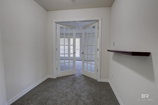 carpeted spare room featuring french doors and a textured ceiling