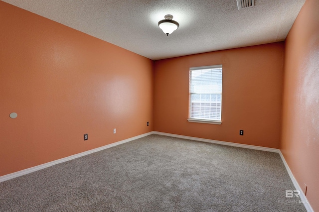 unfurnished room featuring carpet flooring and a textured ceiling