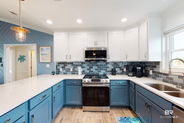 kitchen with white cabinetry, blue cabinets, appliances with stainless steel finishes, and a sink