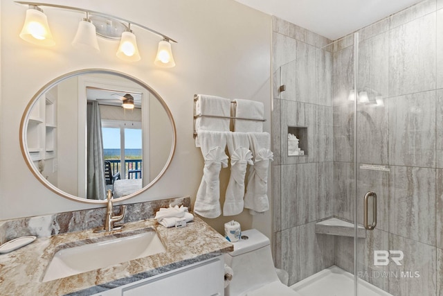 full bathroom featuring a shower stall, toilet, vanity, and ceiling fan