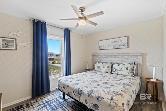 bedroom featuring ceiling fan, baseboards, wood finished floors, and crown molding