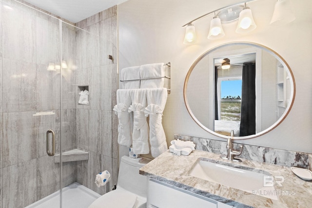 bathroom with vanity, a shower stall, toilet, and ceiling fan