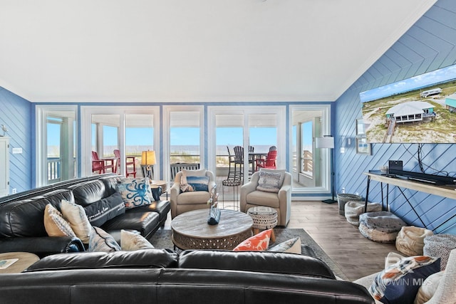 living room featuring a wealth of natural light, lofted ceiling, ornamental molding, and wood finished floors