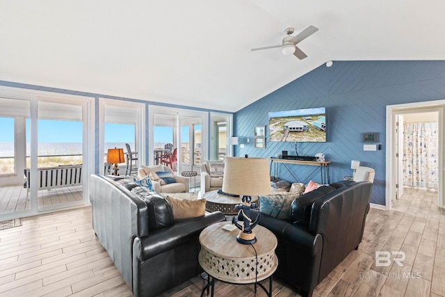 living room with light wood-type flooring, a healthy amount of sunlight, ceiling fan, and vaulted ceiling