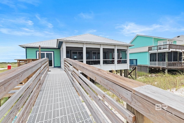 exterior space featuring metal roof and a sunroom