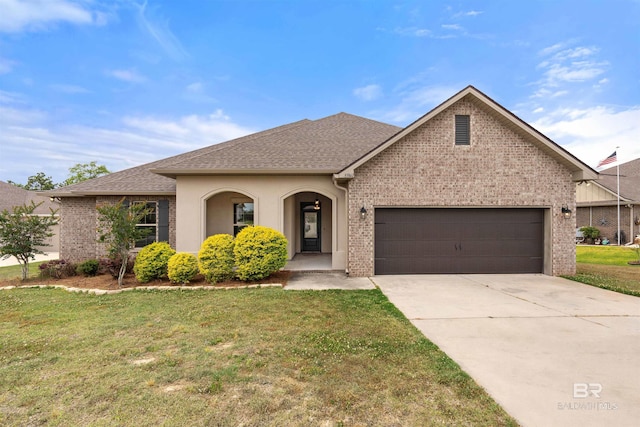 33861 Rutland Ln, Spanish Fort, AL 36527 - view of front of home featuring brick siding, a garage, a front yard, concrete driveway, and a shingled roof