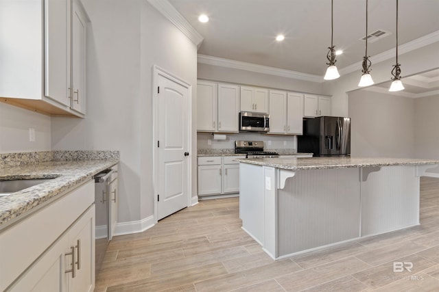 33861 Rutland Ln, Spanish Fort, AL 36527 - kitchen with appliances with stainless steel finishes, crown molding, a kitchen bar, a center island, and white cabinetry