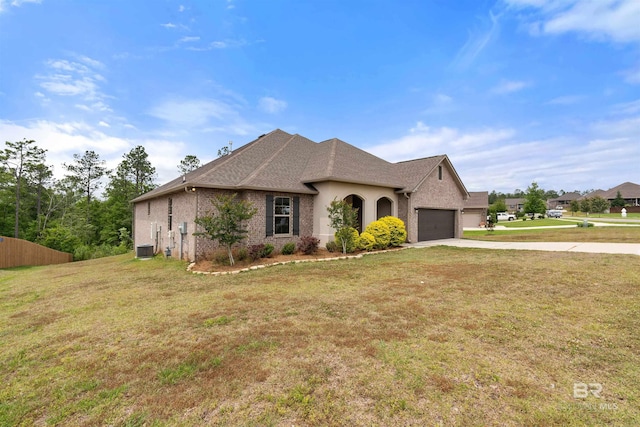 33861 Rutland Ln, Spanish Fort, AL 36527 - french country home with concrete driveway, an attached garage, a front lawn, cooling unit, and brick siding