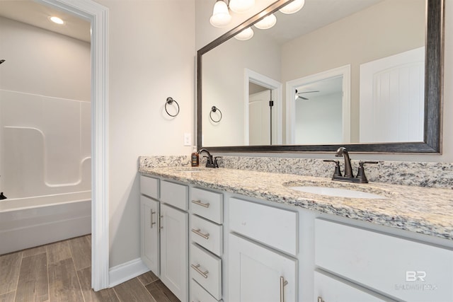 33861 Rutland Ln, Spanish Fort, AL 36527 - full bath featuring double vanity, wood finished floors, baseboards,  shower combination, and ceiling fan