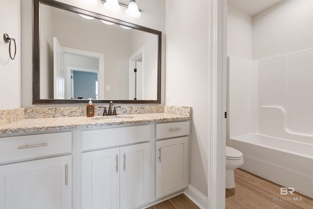 33861 Rutland Ln, Spanish Fort, AL 36527 - bathroom with toilet, vanity, wood finished floors, and shower / tub combination