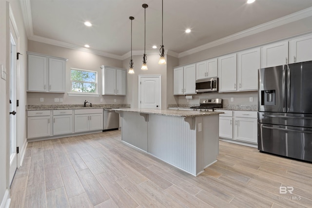 33861 Rutland Ln, Spanish Fort, AL 36527 - kitchen featuring appliances with stainless steel finishes, a kitchen bar, a kitchen island, hanging light fixtures, and a sink