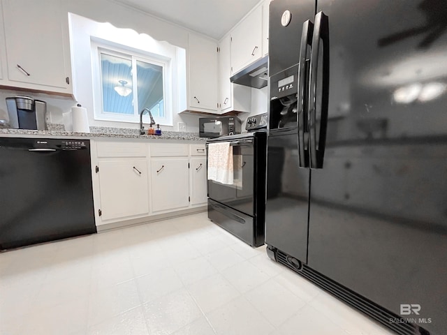 kitchen with white cabinets, light stone countertops, and black appliances