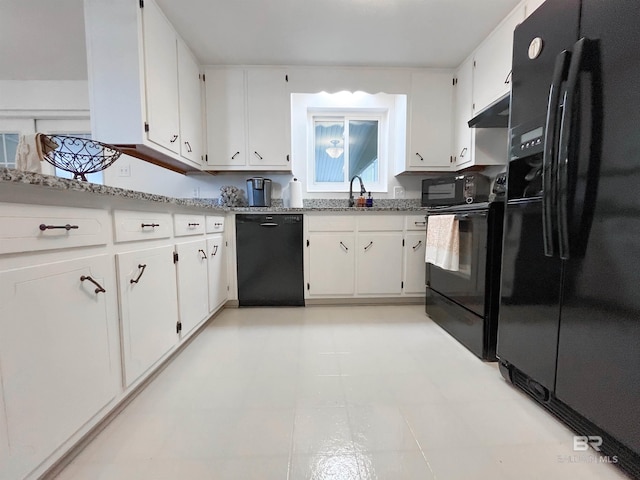 kitchen with white cabinetry, black appliances, sink, and light stone counters