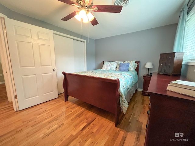 bedroom with ceiling fan, a closet, and light hardwood / wood-style flooring