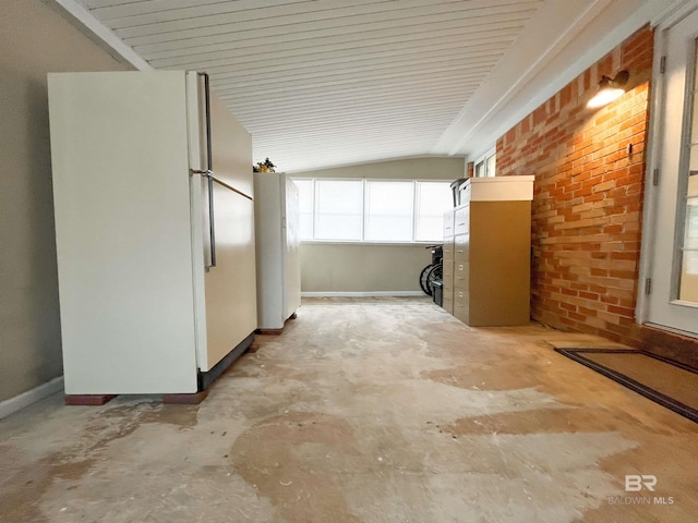 interior space featuring brick wall and vaulted ceiling