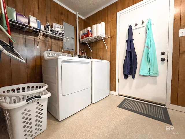 washroom with a textured ceiling, wooden walls, and washing machine and clothes dryer