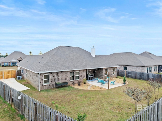 back of property with a lawn, a patio, and central AC unit