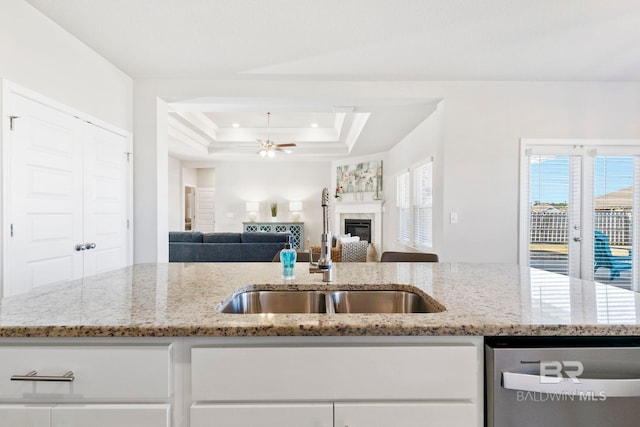 kitchen featuring a kitchen island with sink, light stone countertops, sink, and stainless steel dishwasher