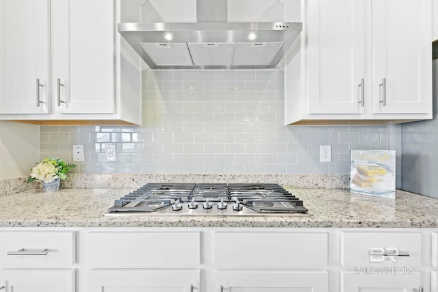 kitchen with white cabinetry, wall chimney range hood, and tasteful backsplash