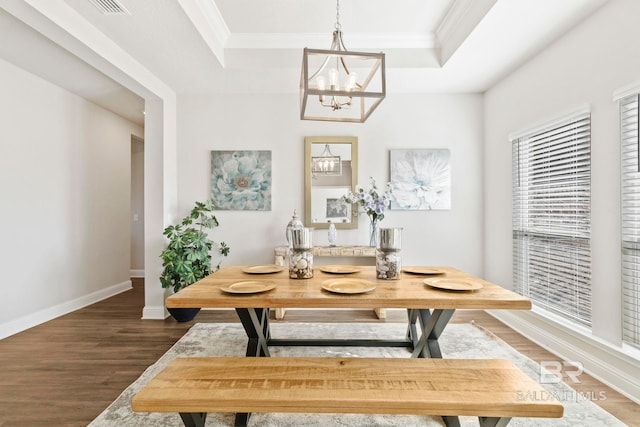 dining area featuring a chandelier, a tray ceiling, and dark hardwood / wood-style floors