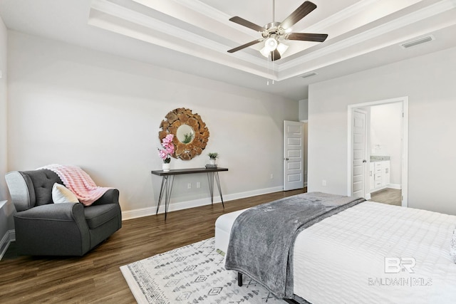 bedroom featuring ensuite bathroom, ornamental molding, a raised ceiling, ceiling fan, and dark hardwood / wood-style floors