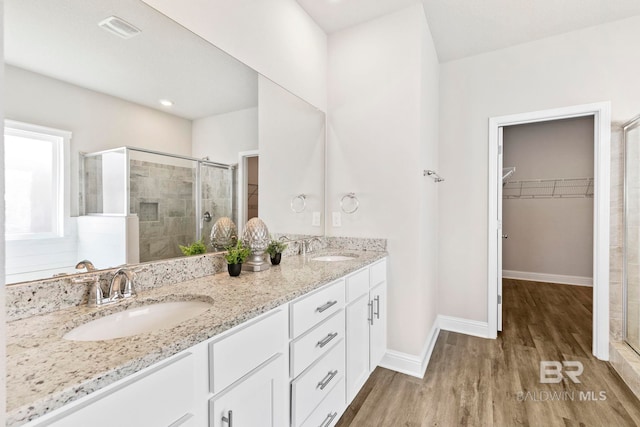 bathroom with vanity, hardwood / wood-style flooring, and a shower with shower door