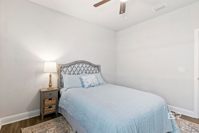 bedroom with dark hardwood / wood-style flooring and ceiling fan