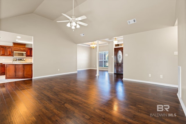 unfurnished living room featuring vaulted ceiling, dark wood-type flooring, and ceiling fan with notable chandelier