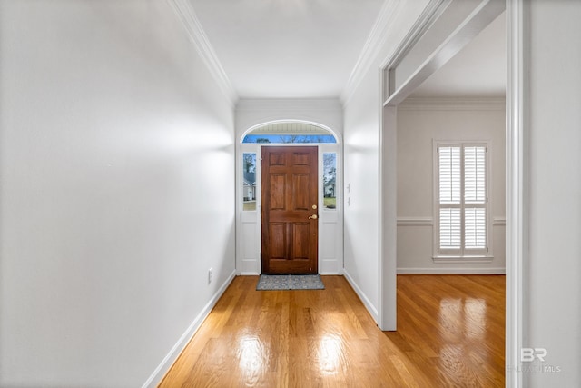 entryway featuring light wood-type flooring, crown molding, and baseboards