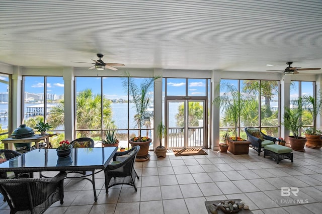 sunroom with tile patterned floors and a water view