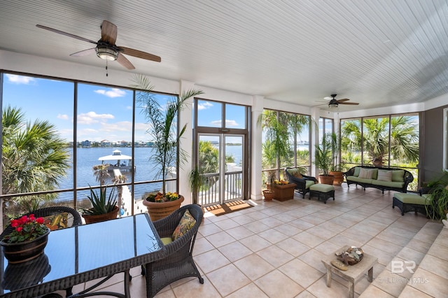 sunroom / solarium featuring outdoor lounge area, tile patterned flooring, a water view, and ceiling fan