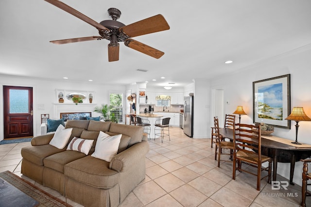 living area featuring recessed lighting, a ceiling fan, ornamental molding, and light tile patterned floors
