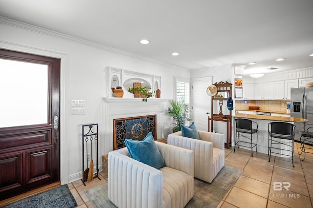 living area with light tile patterned floors, recessed lighting, crown molding, and a fireplace