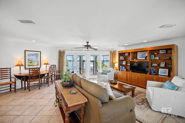 living room featuring ceiling fan, visible vents, ornamental molding, and light tile patterned flooring