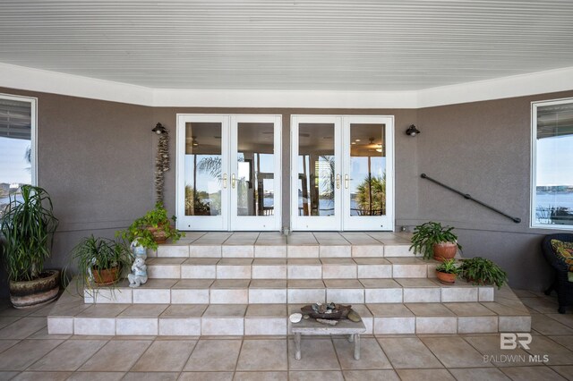 entrance to property featuring french doors and stucco siding