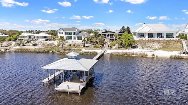 view of dock with boat lift, a water view, and a residential view