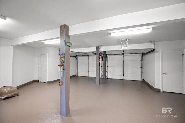 garage with baseboards and a garage door opener