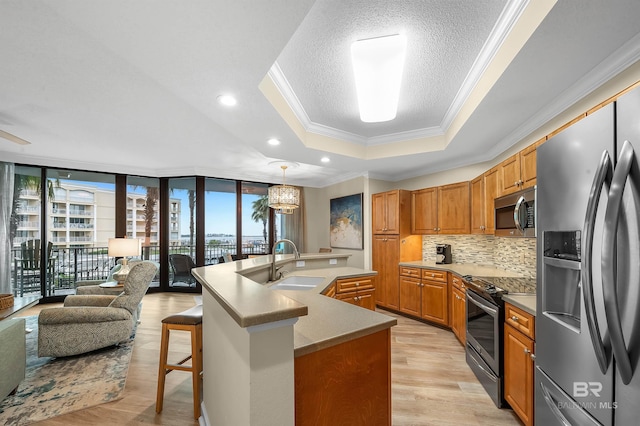 kitchen featuring an island with sink, appliances with stainless steel finishes, plenty of natural light, and sink