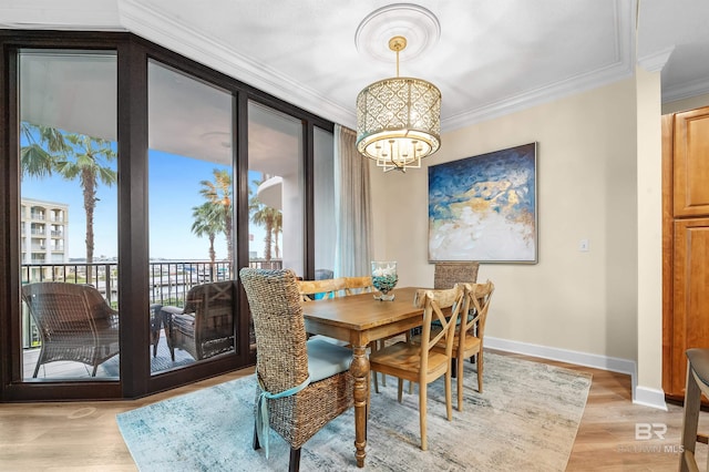 dining area with light wood-type flooring and crown molding