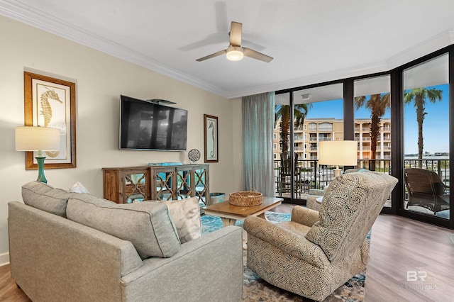 living room featuring ceiling fan, a wall of windows, crown molding, and hardwood / wood-style floors