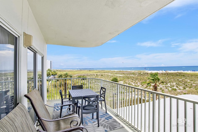 balcony with a water view and a view of the beach