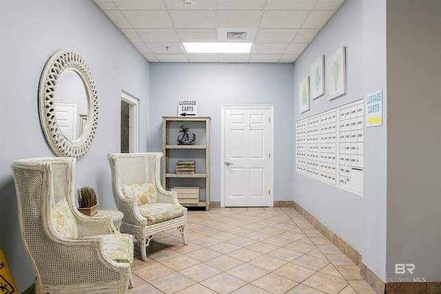 sitting room featuring light tile patterned floors, mail boxes, and a drop ceiling